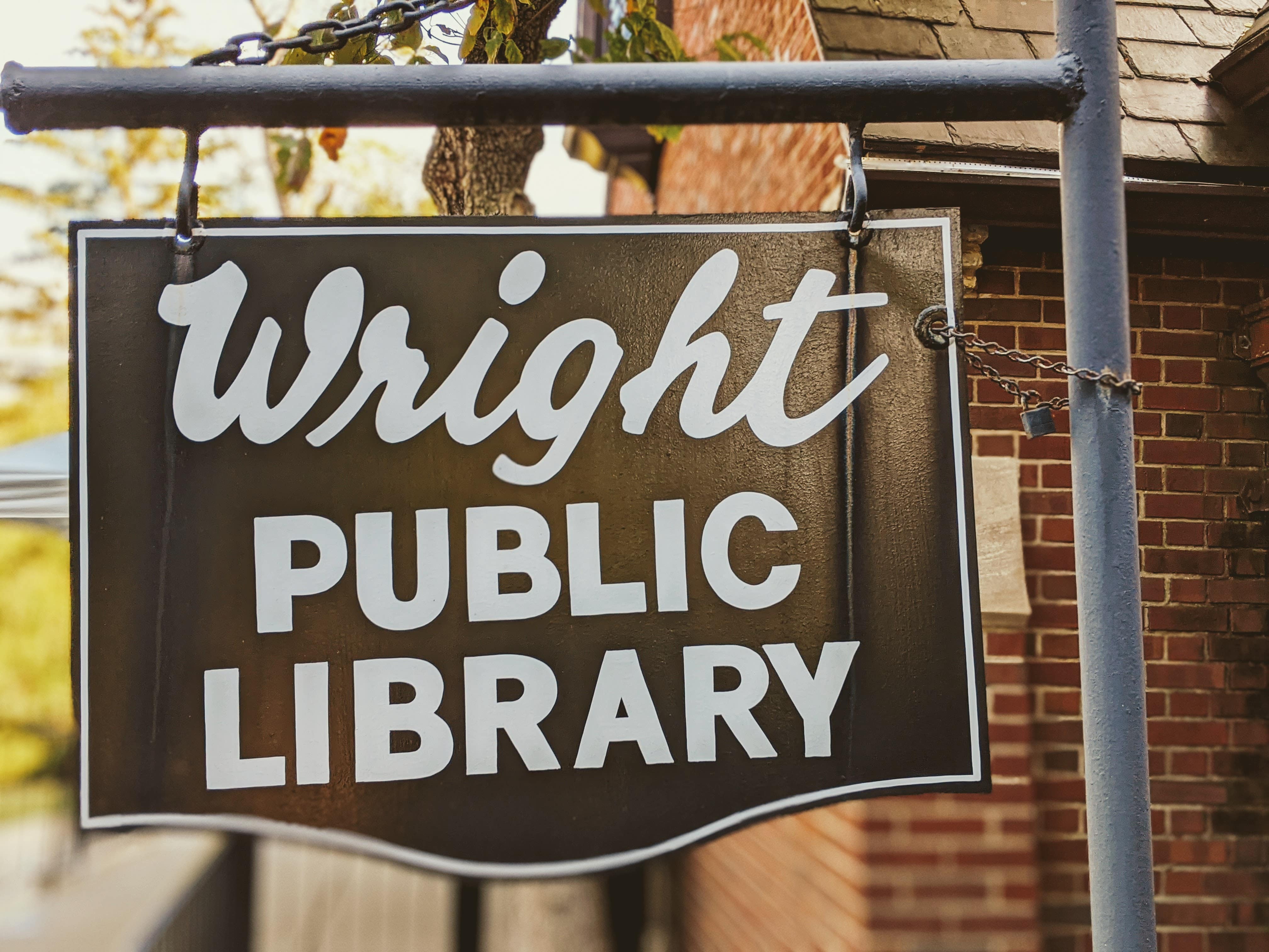 Black and white metal sign saying "wright public library"