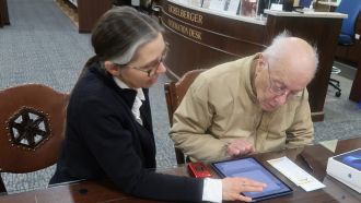 Librarian assists patron using a tablet