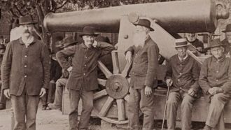 Civil War soldiers in Dayton Ohio pose in front of a large canon.