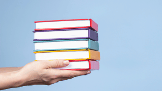 Hand holder a stack of colorful books