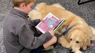 Boy reads to a therapy dog.