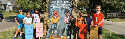 Youth Library Ambassadors pose with Wright Library's Scarecrow Row Display: The Mystery of the Missing Library Book