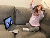 toddler holding hands up like the librarian on her laptop is